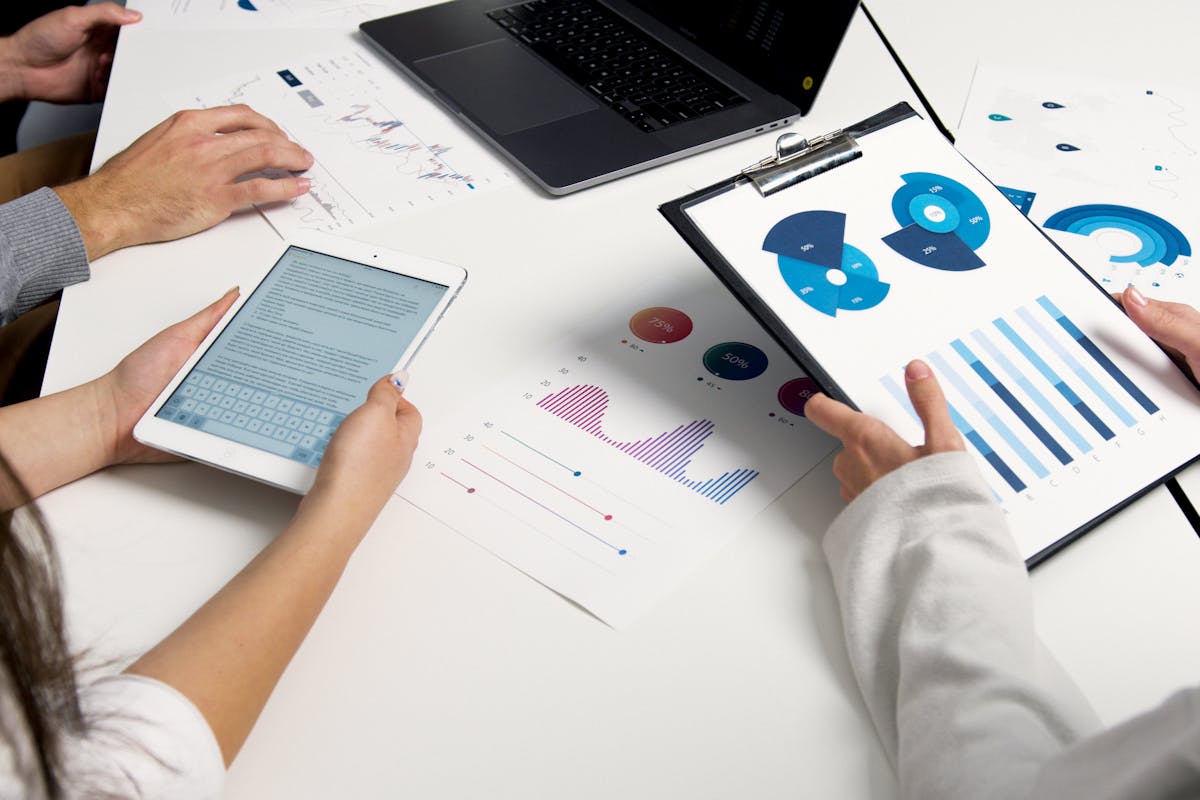 Team analyzing financial charts and digital reports during a business meeting
