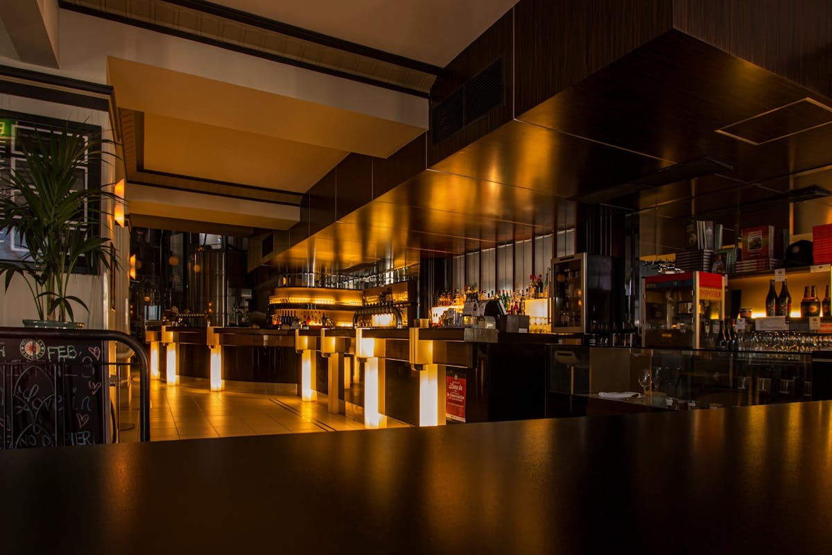 Stylish modern restaurant interior with warm lighting, elegant design, and luxurious ambiance at night.