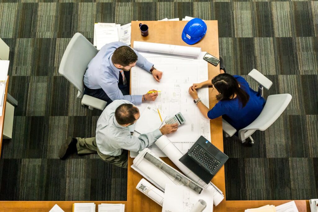Top view of a team working on construction plans in an office setting.