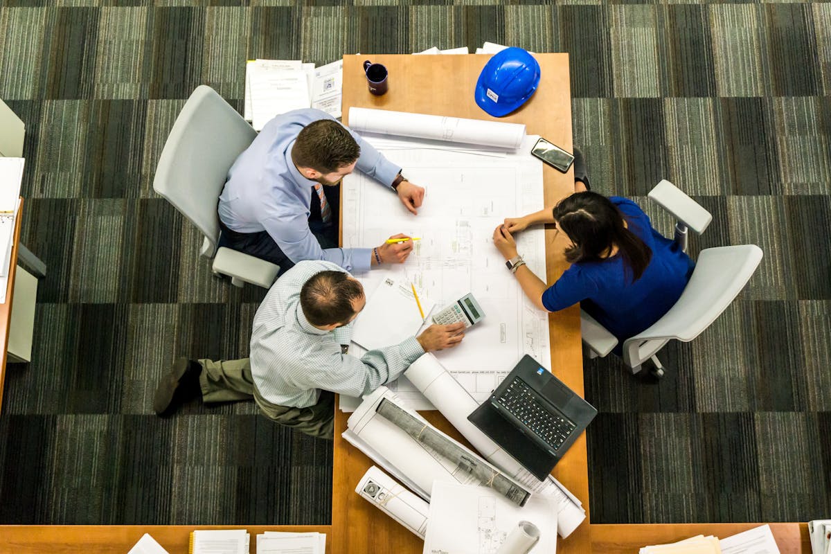 Top view of a team working on construction plans in an office setting.